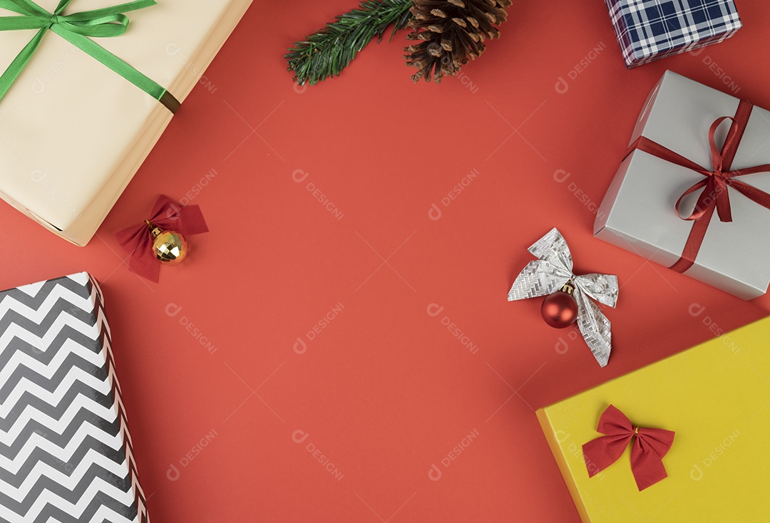 Caixas de presente e bolas de natal sobre fundo vermelho.