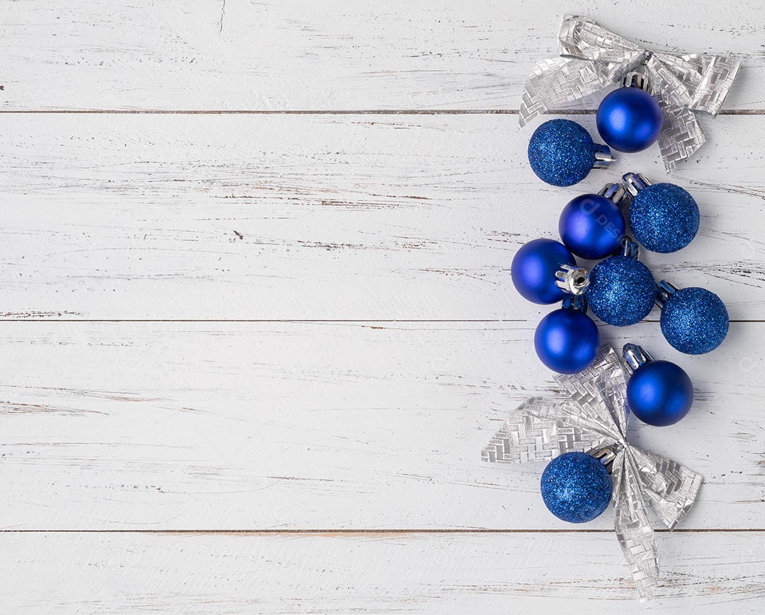 Bolas de Natal e arcos sobre a mesa de madeira.