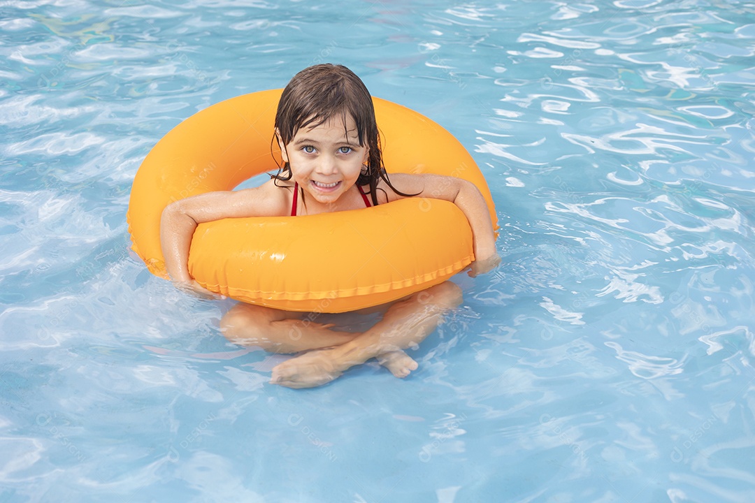 Menina banhando na piscina para crianças com sua boia.