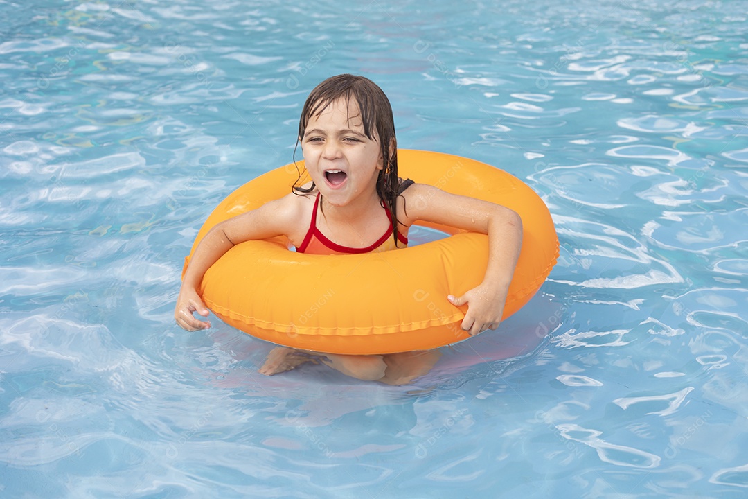 Menina banhando na piscina para crianças com sua boia.