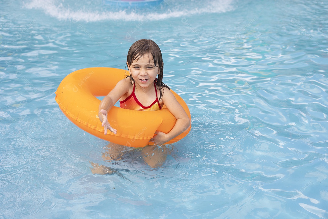 Menina banhando na piscina para crianças com sua boia.