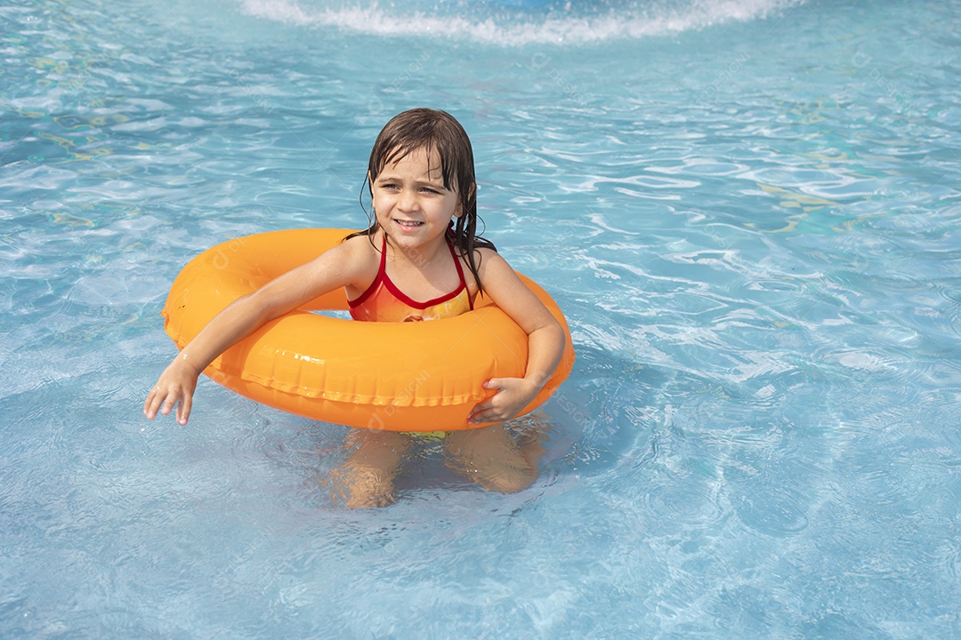 Menina banhando na piscina para crianças com sua boia.