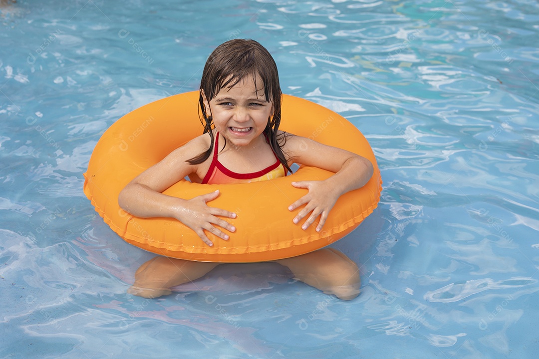 Menina banhando na piscina para crianças com sua boia.