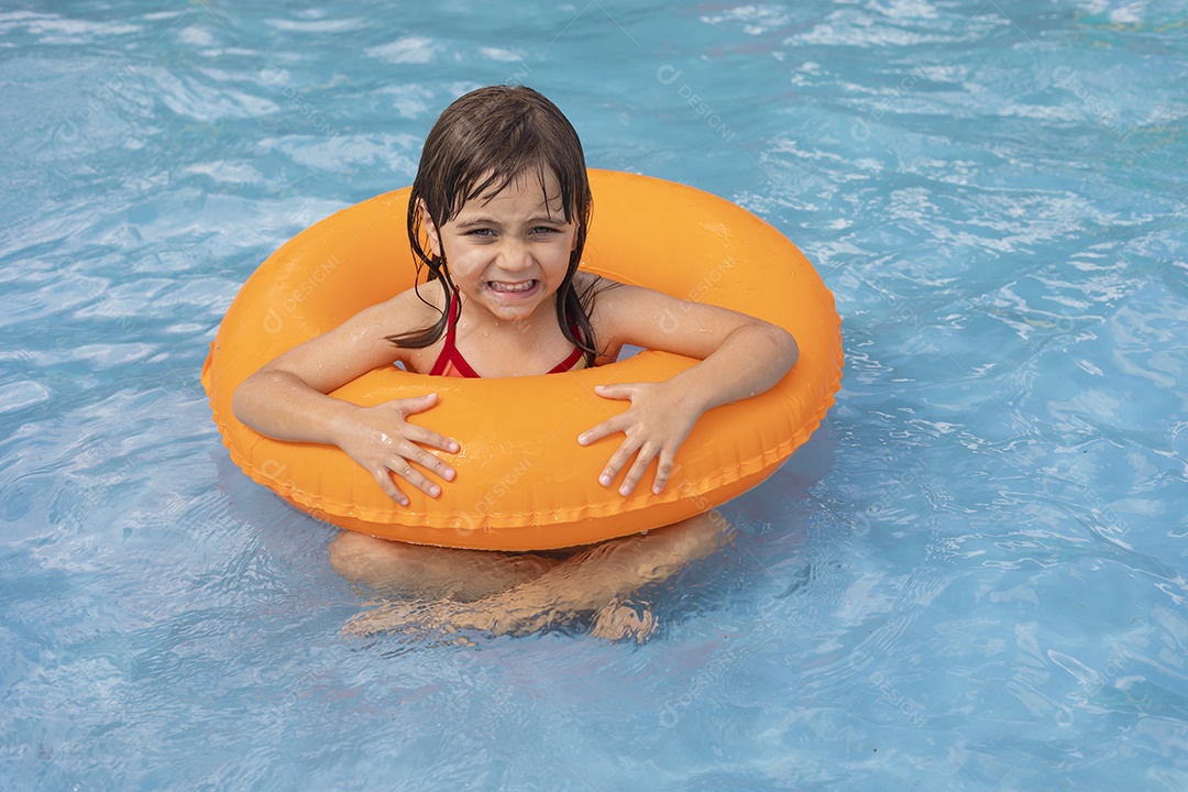 Menina banhando na piscina para crianças.com sua boia.