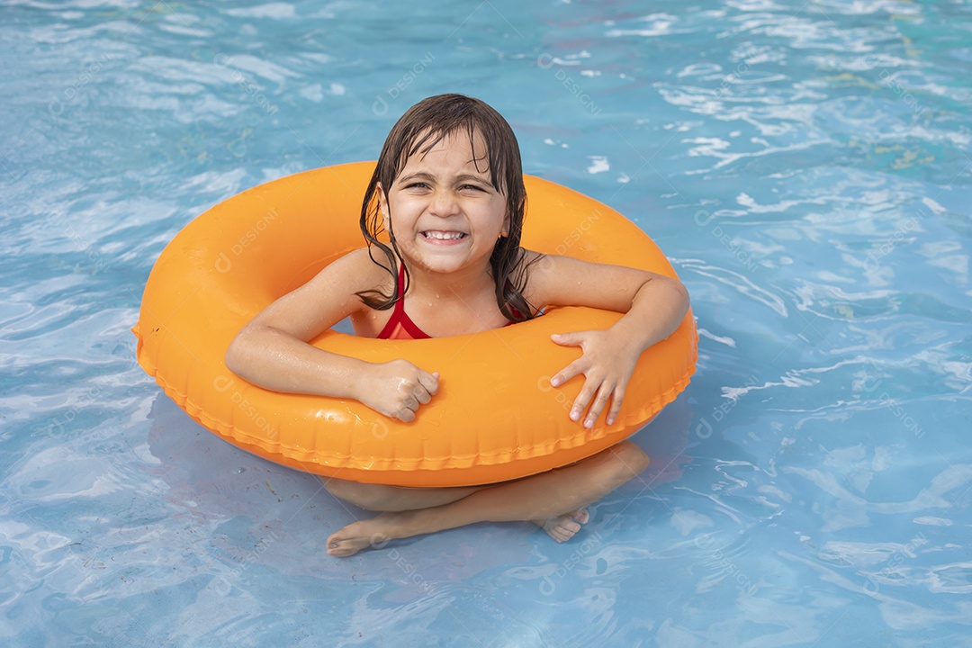 Menina banhando na piscina para crianças.com sua boia.