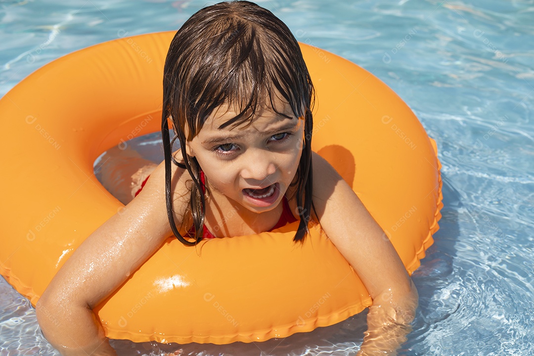 Menina banhando na piscina para crianças com sua boia.