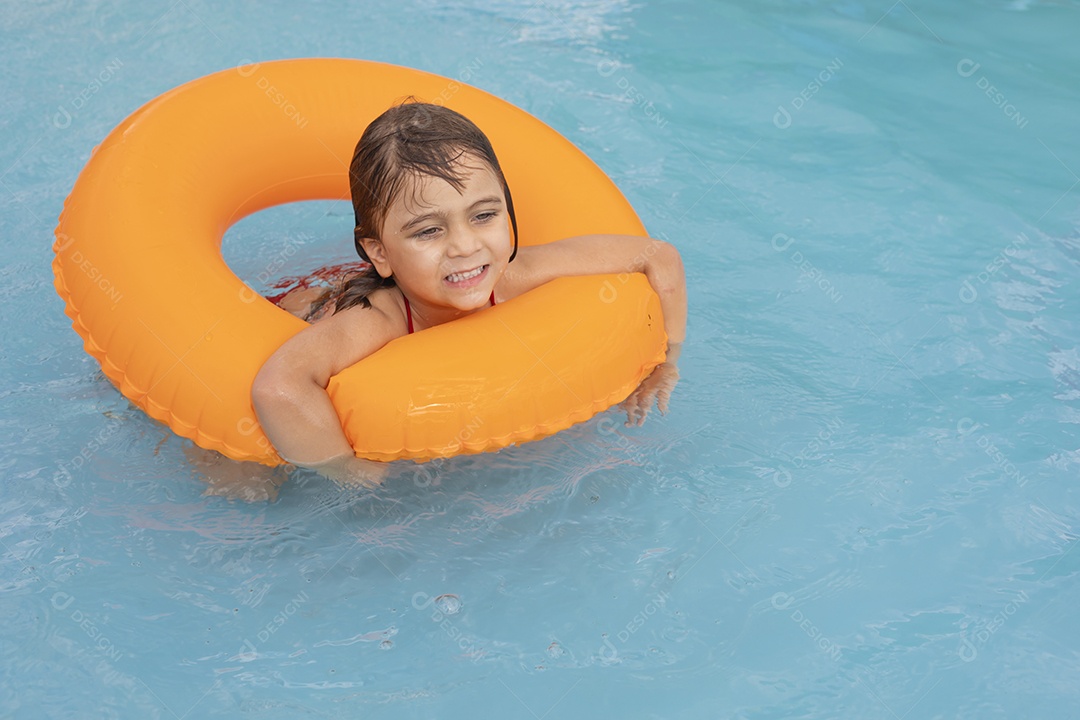 Menina banhando na piscina para crianças com sua boia.