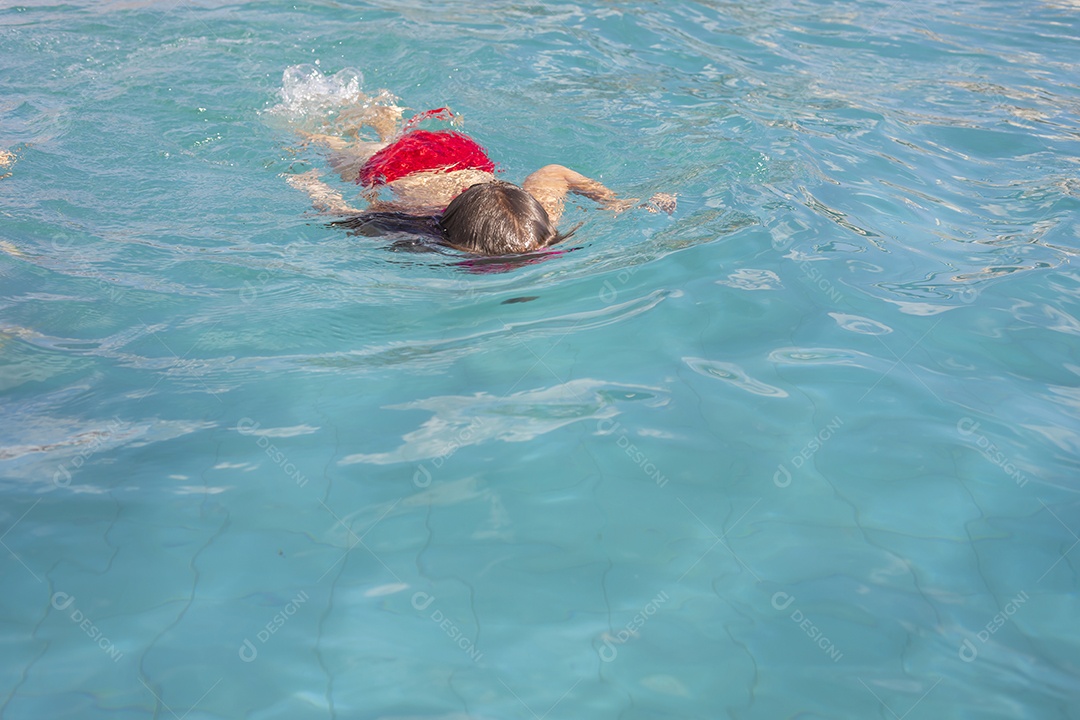 Menina banhando na piscina para crianças.