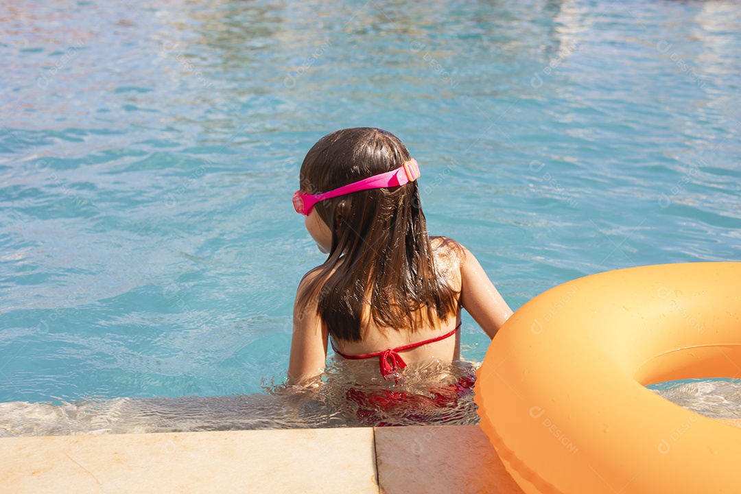 Menina banhando na piscina para crianças.
