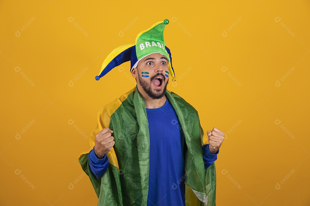 Homem jovem torcedor brasileiro sobre fundo amarelo