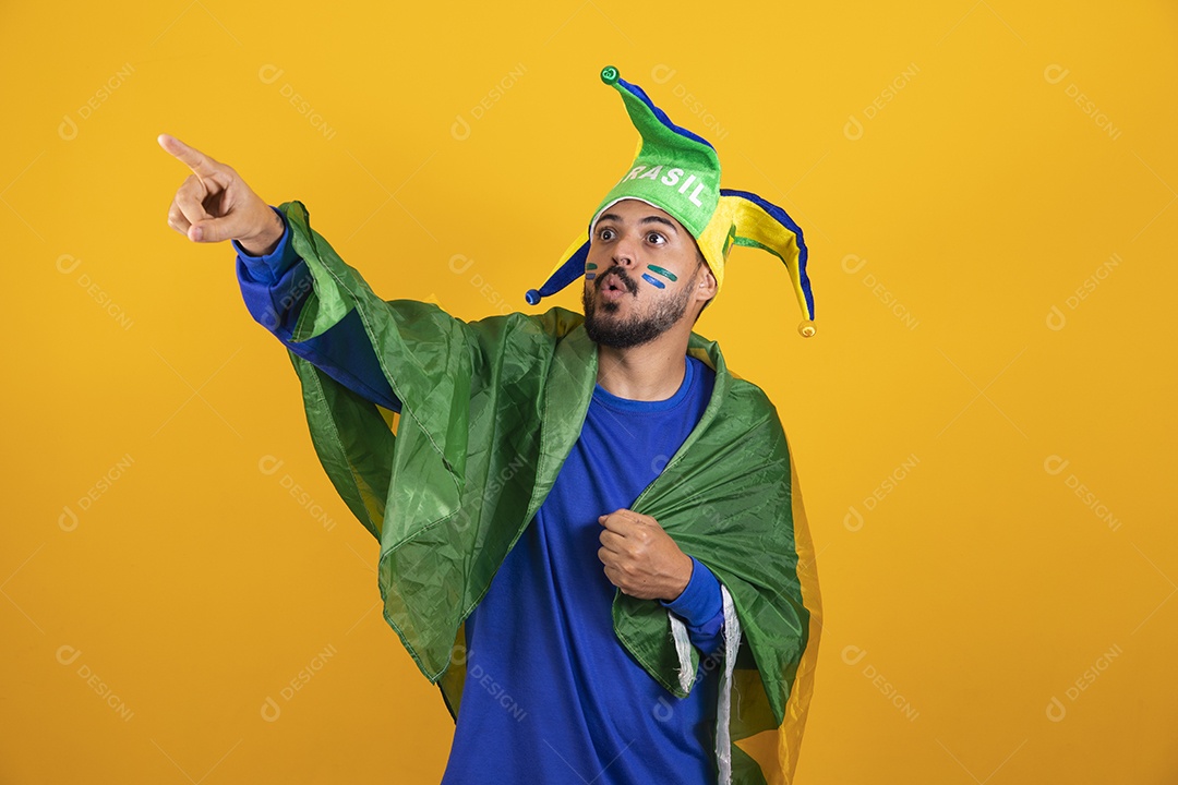 Homem jovem torcedor brasileiro sobre fundo amarelo