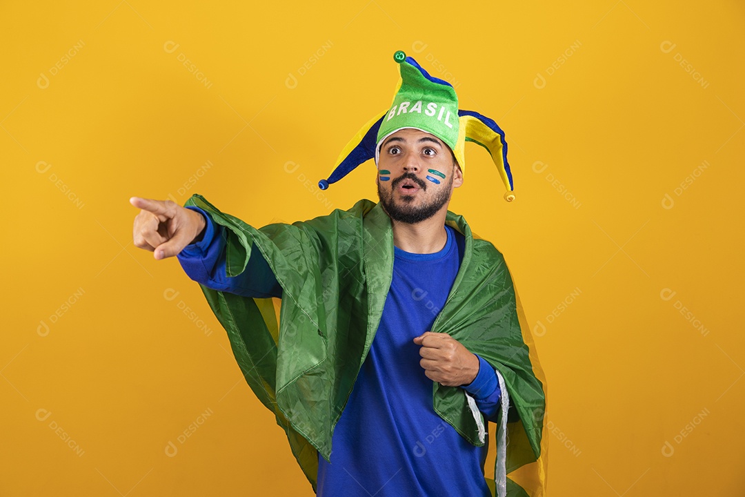 Homem jovem torcedor brasileiro sobre fundo amarelo