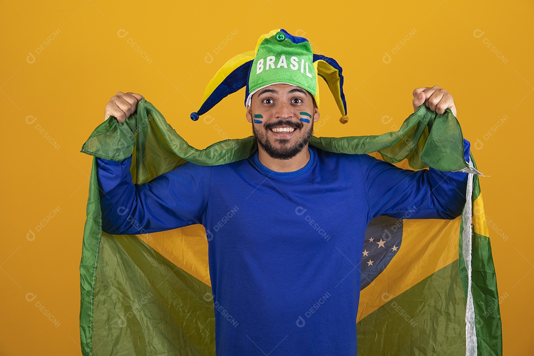 Homem jovem torcedor brasileiro sobre fundo amarelo