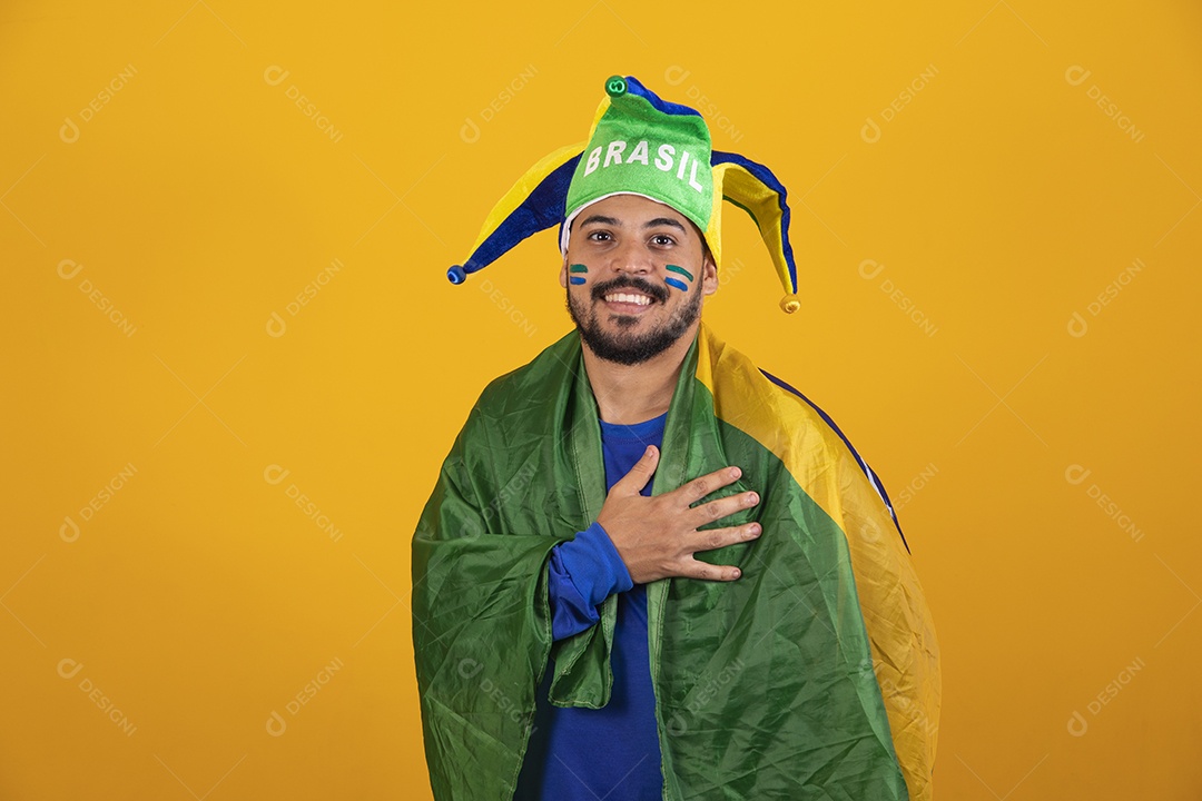 Homem jovem torcedor brasileiro sobre fundo amarelo