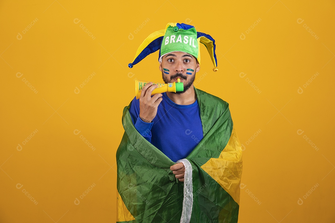 Homem jovem torcedor brasileiro sobre fundo amarelo