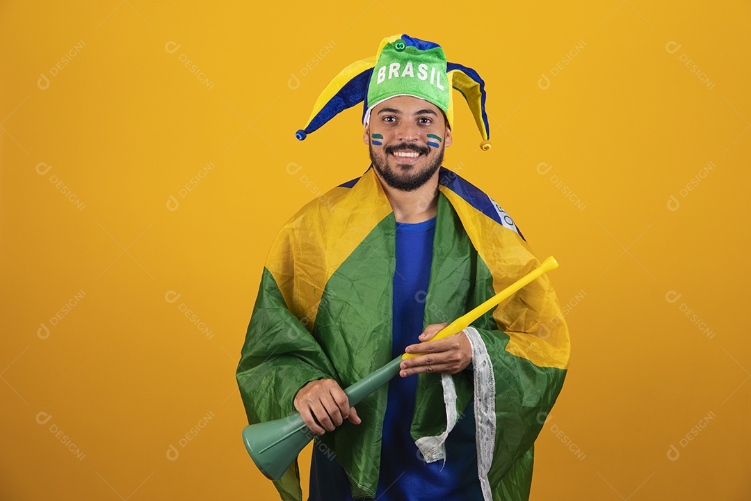 Homem jovem torcedor brasileiro sobre fundo amarelo