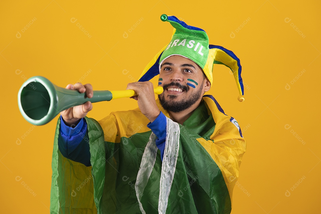 Homem jovem torcedor brasileiro sobre fundo amarelo