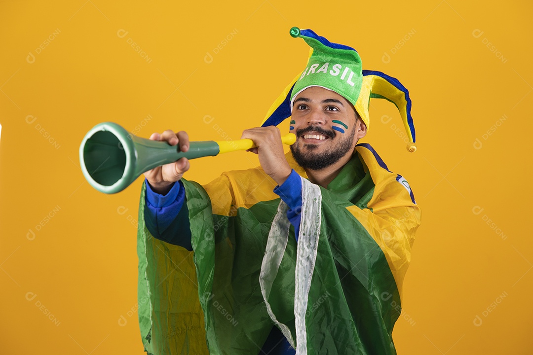 Homem jovem torcedor brasileiro sobre fundo amarelo