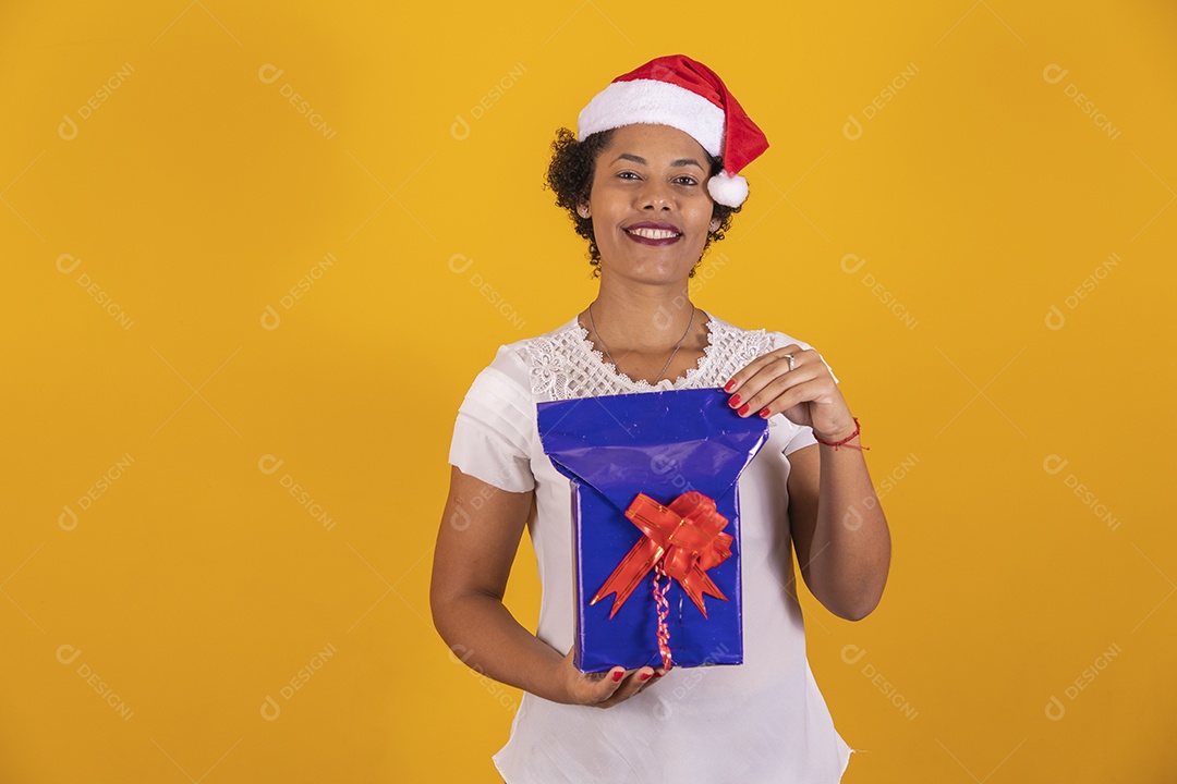 Linda mulher jovem segurando presente usando gorro do Papai Noel