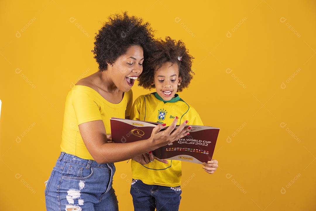 Mae e sua filha segurando álbum da copa do brasil de 2022 futebol