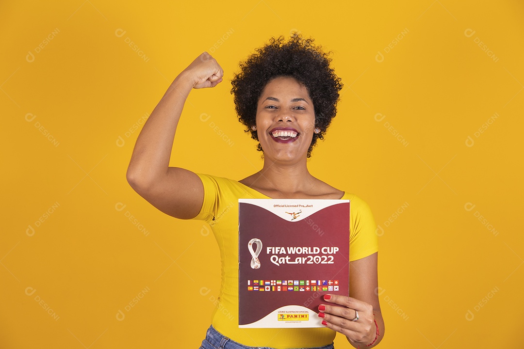 Linda mulher jovem morena segurando álbum da copa do brasil de 2022 futebol