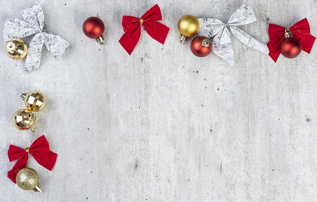 Bolas de natal e arcos de presente sobre mesa de madeira.