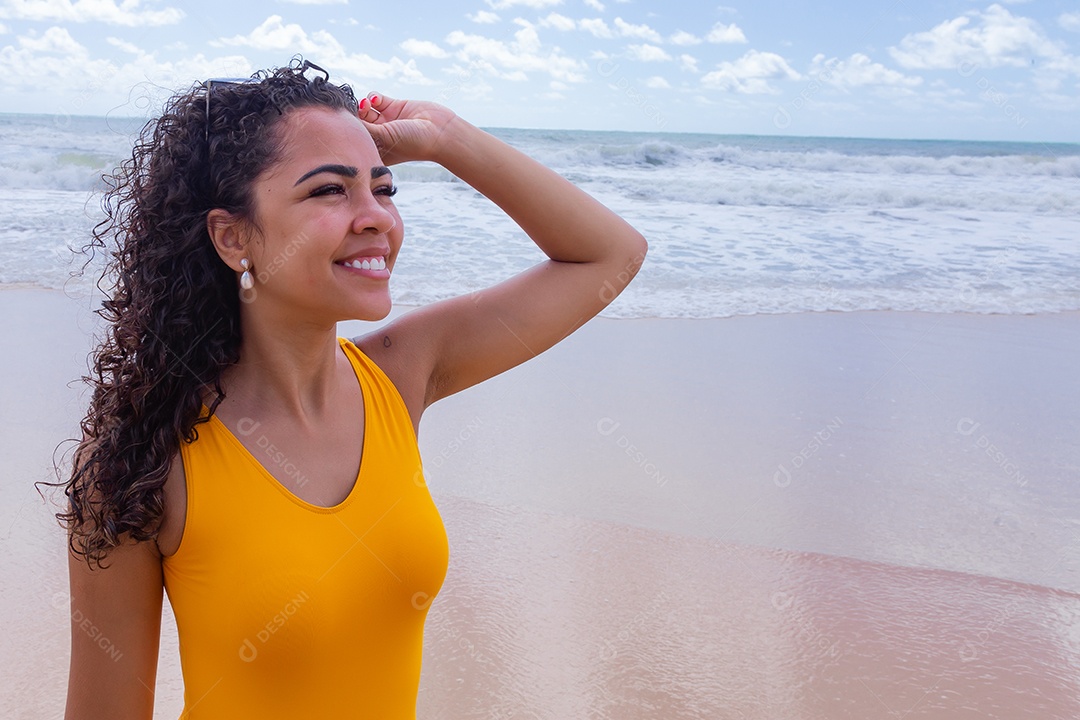 Linda mulher usando trajes de banho sobre praia curtindo verão