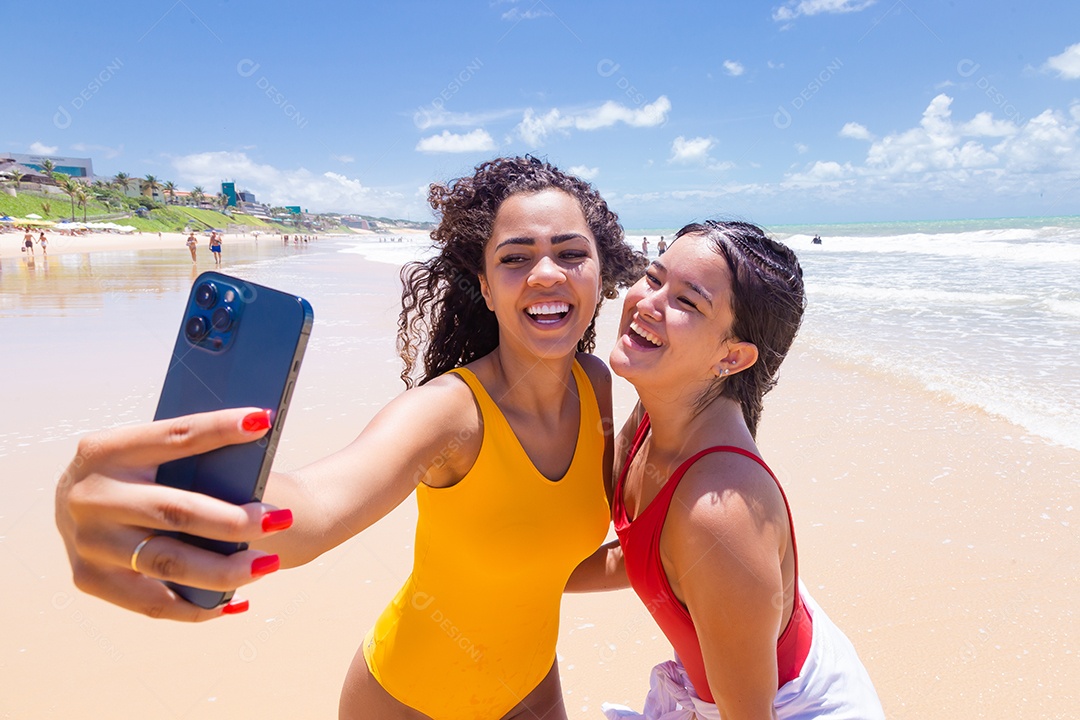 Lindas mulheres usando trajes de banho sobre praia curtindo verão