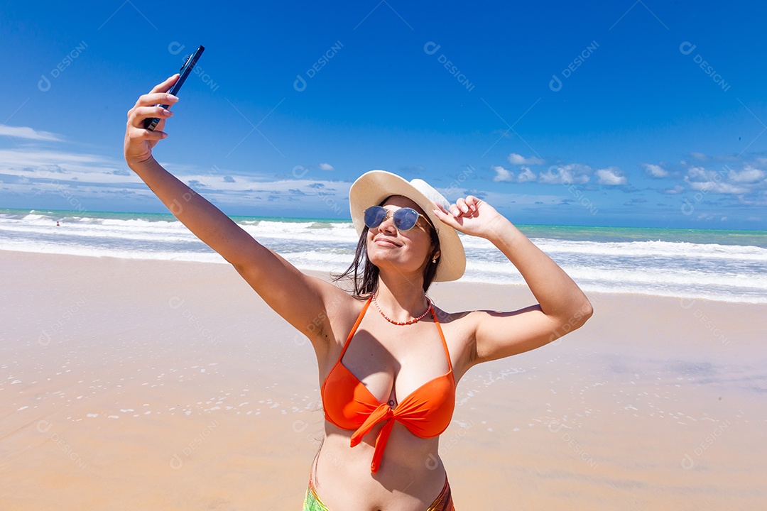 Linda mulher tirando selfie usando trajes de banho sobre praia curtindo verão