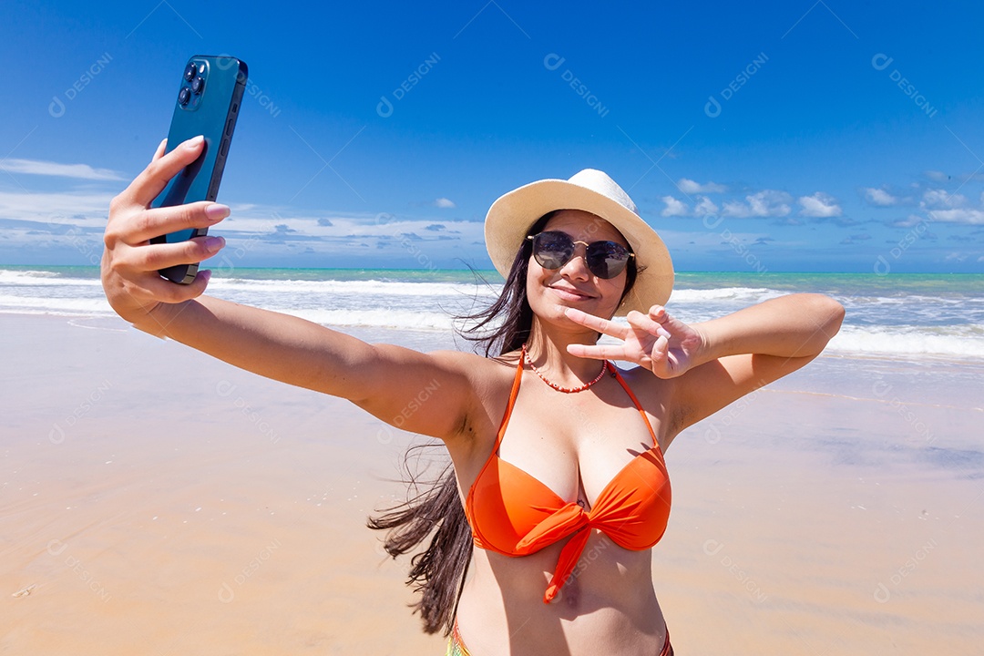 Linda mulher tirando selfie usando trajes de banho sobre praia curtindo verão