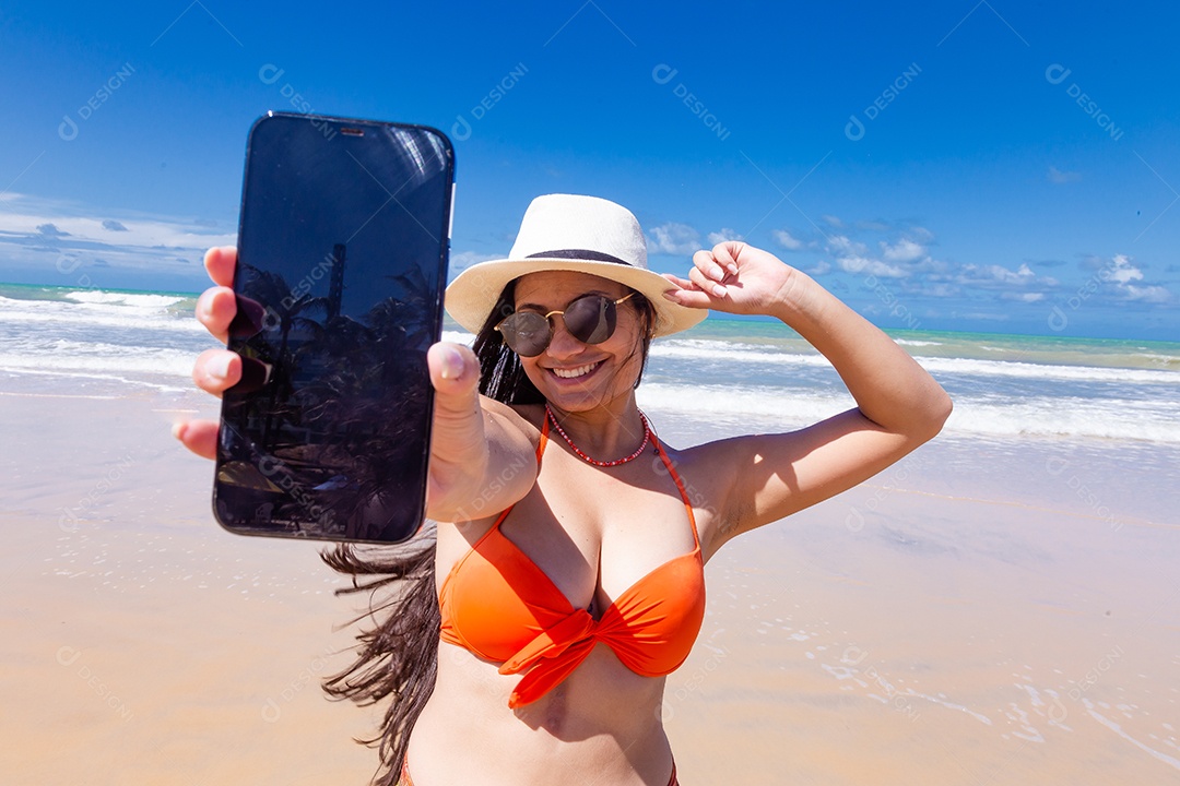 Linda mulher tirando selfie usando trajes de banho sobre praia curtindo verão