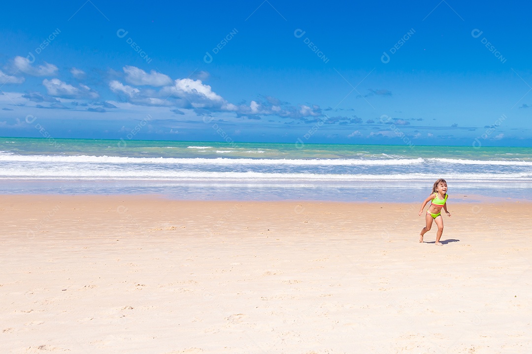 Linda menina garotinha usando roupas de banho sobre praia curtindo verão