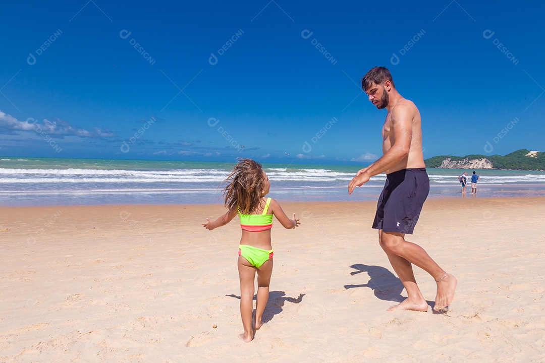 Pai brincando com sua filha sobre praia feliz férias família