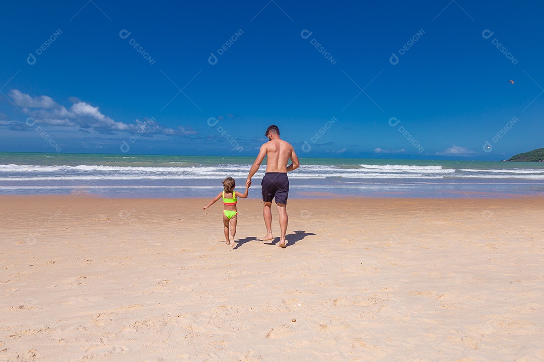 Pai brincando com sua filha sobre praia feliz férias família