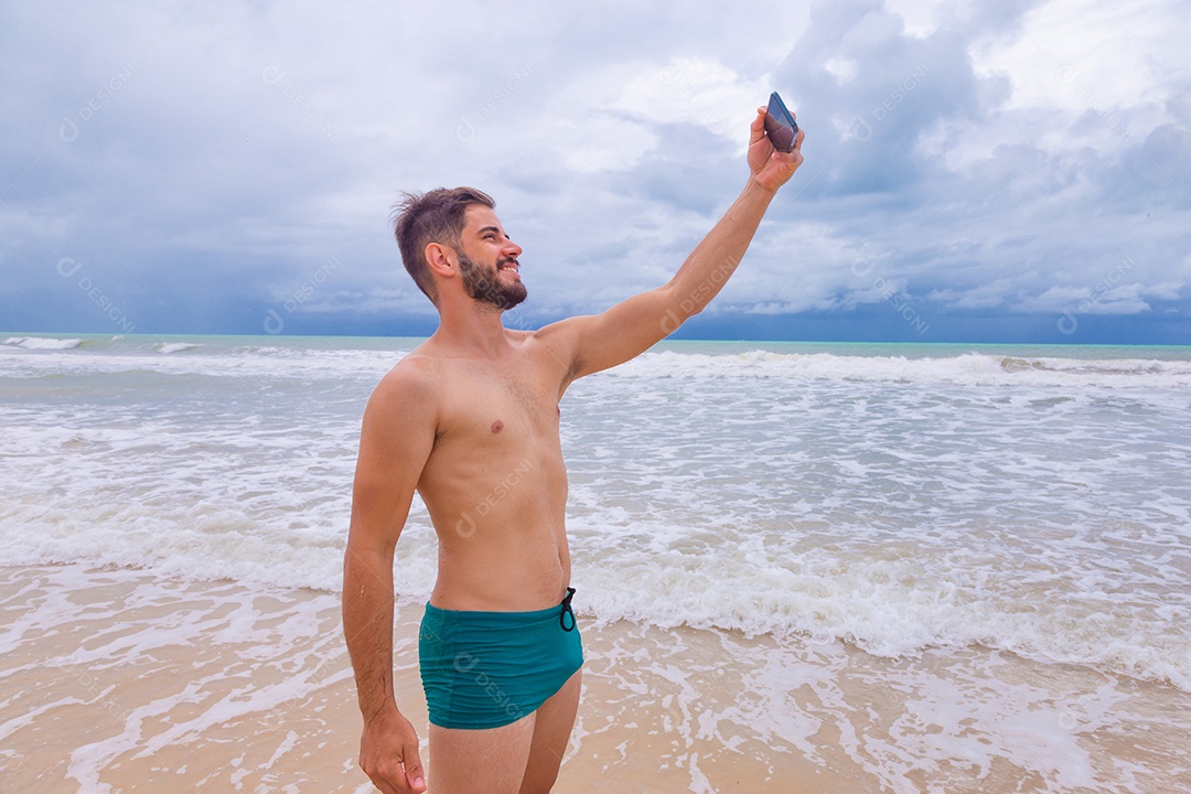 Homem jovem curtindo férias sobre uma praia