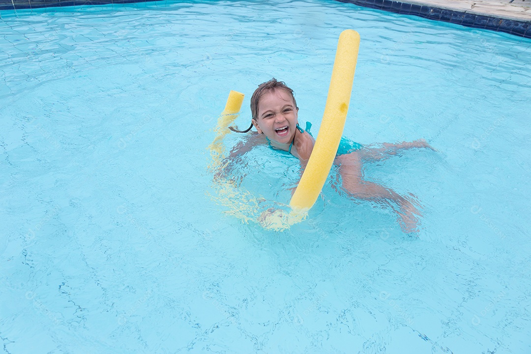 Linda menina garotinha usando biquini sobre piscina curtindo verão