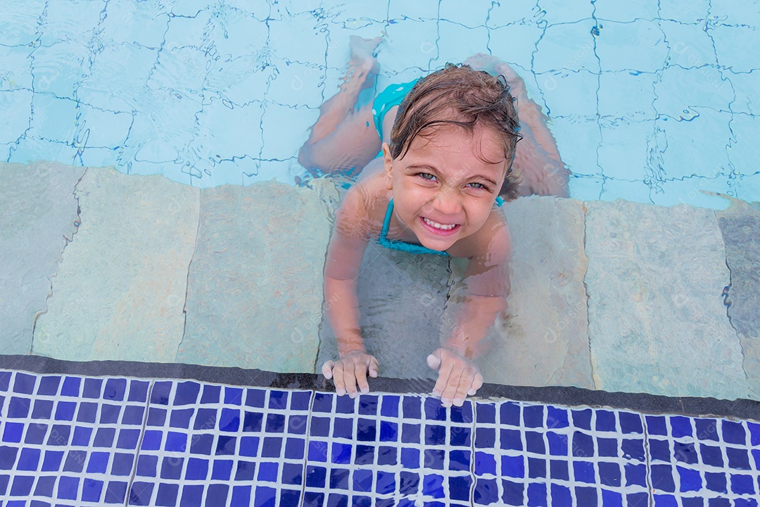 Linda menina garotinha usando biquini sobre piscina curtindo verão