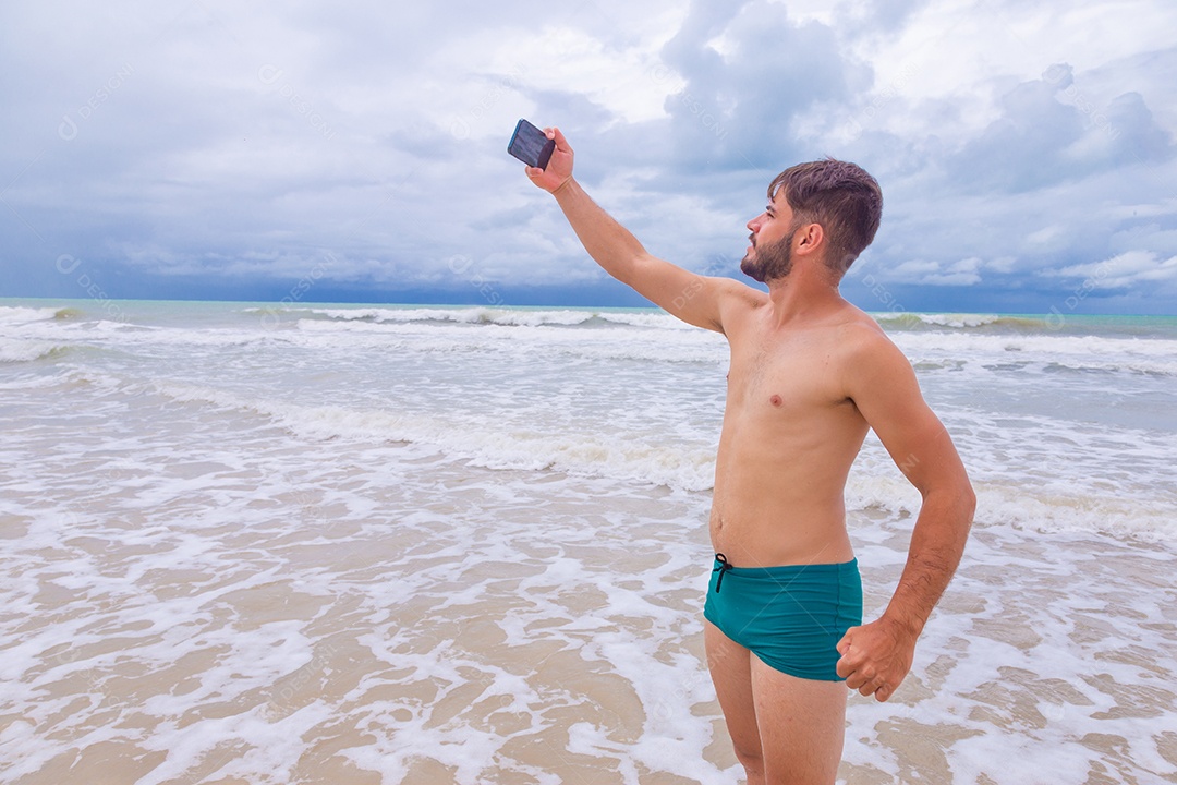 Homem jovem curtindo férias sobre uma praia