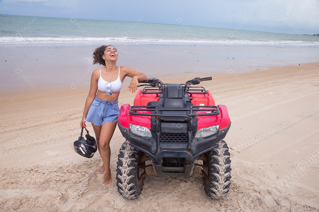 Linda mulher curtindo férias andando de quadriciclo sobre dunas