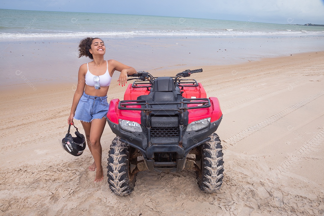Linda mulher curtindo férias andando de quadriciclo sobre dunas