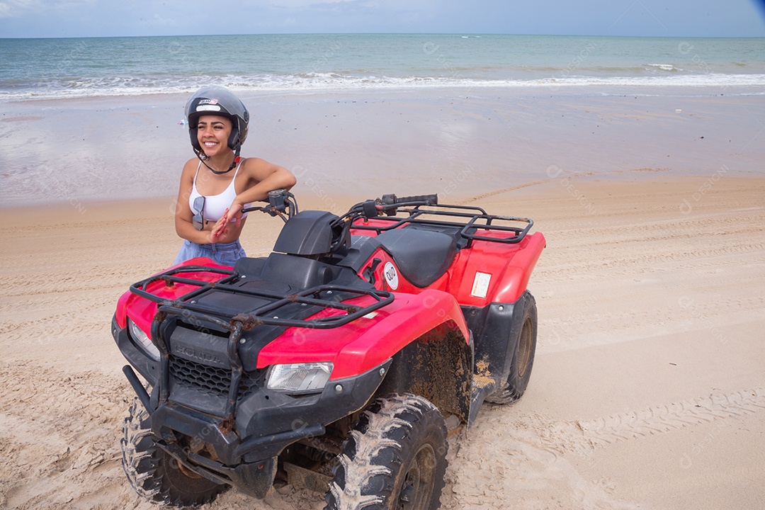 Linda mulher curtindo férias andando de quadriciclo sobre dunas