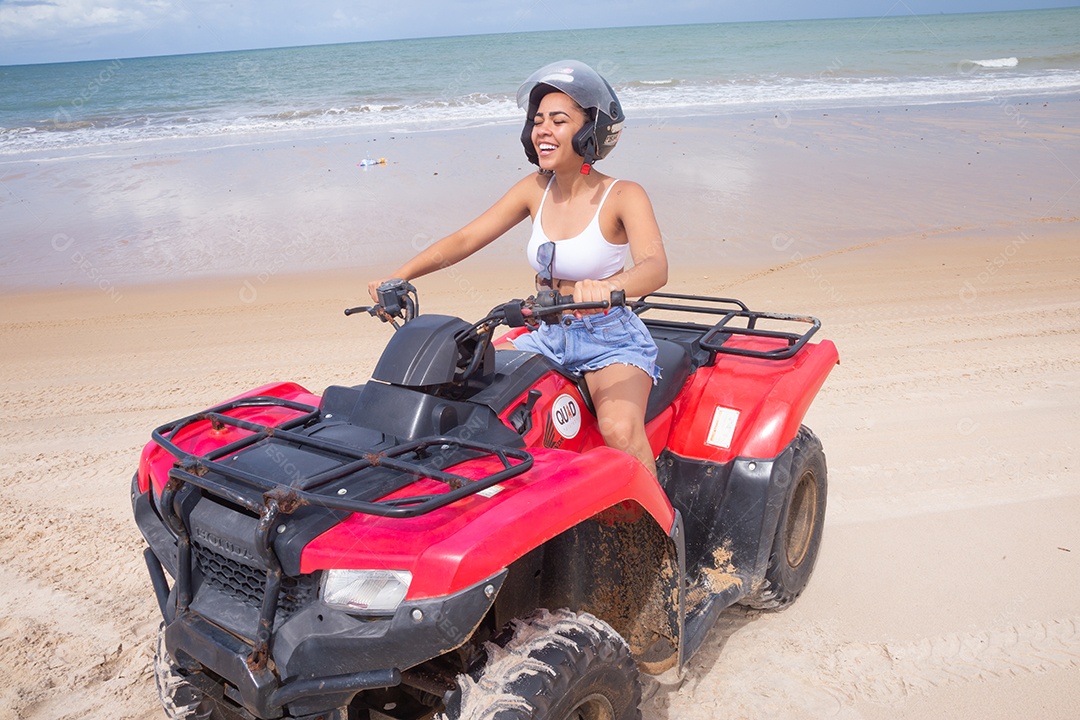 Linda mulher curtindo férias andando de quadriciclo sobre dunas