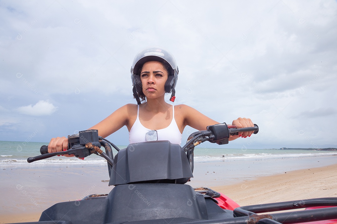 Linda mulher curtindo férias andando de quadriciclo sobre dunas