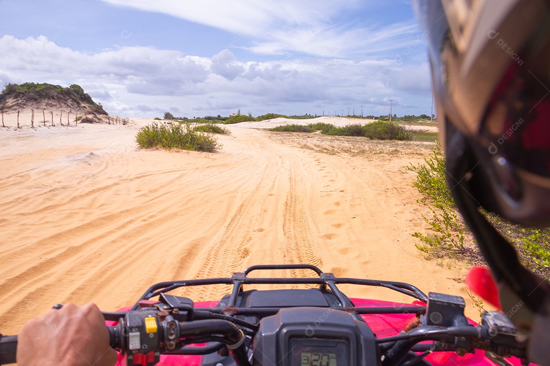 Pessoas curtindo férias andando de quadriciclo sobre dunas