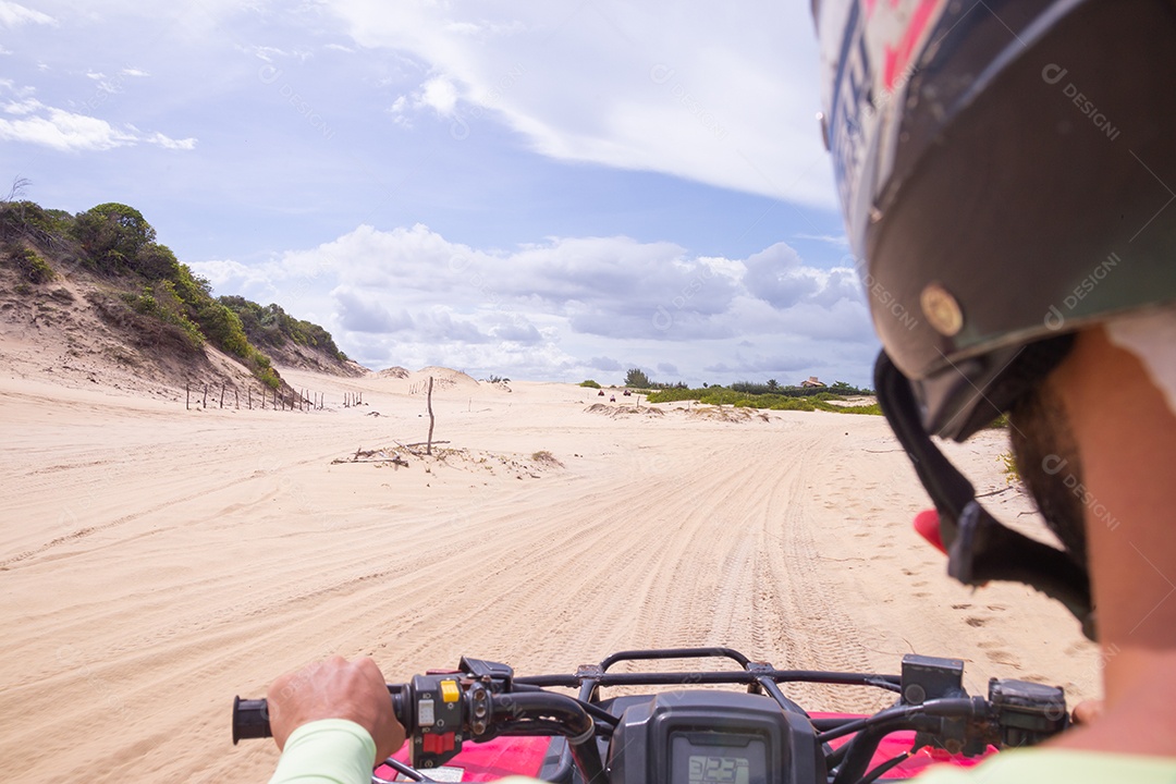 Pessoas curtindo férias andando de quadriciclo sobre dunas