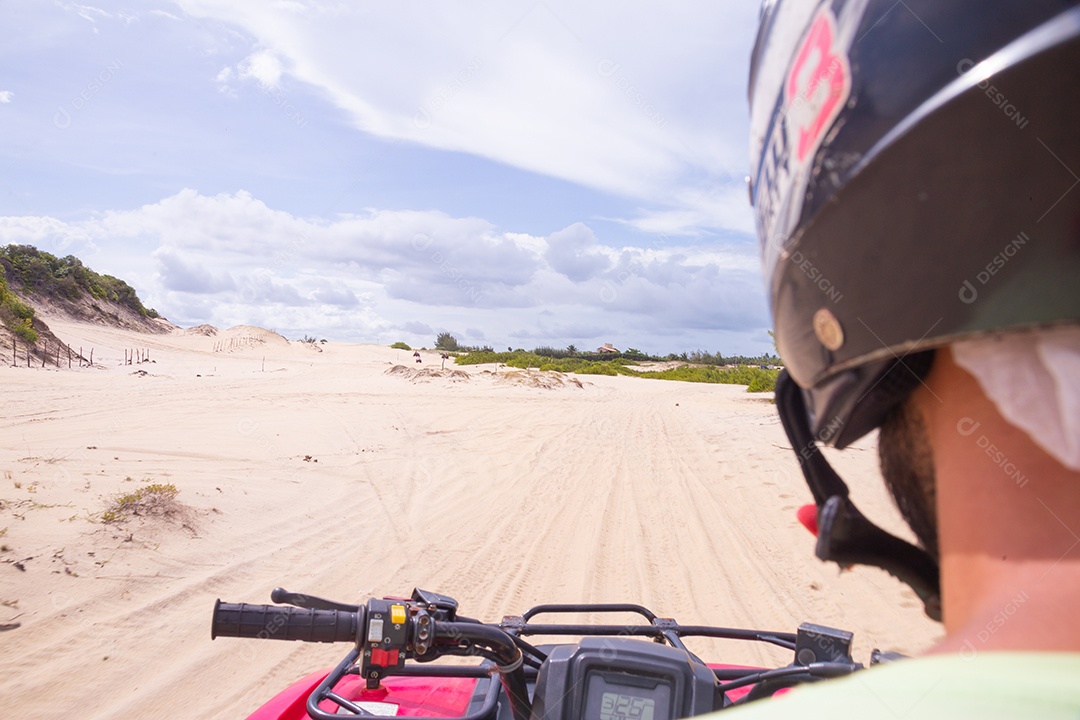 Pessoas curtindo férias andando de quadriciclo sobre dunas