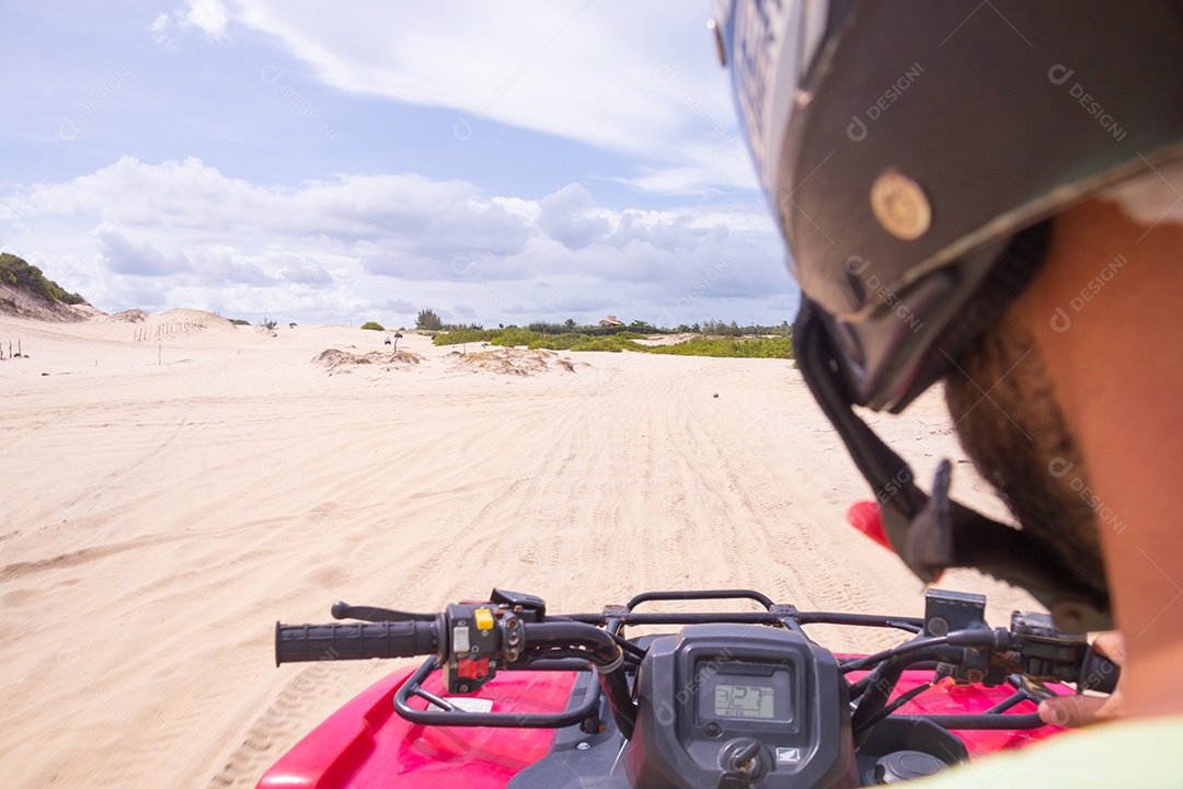 Pessoas curtindo férias andando de quadriciclo sobre dunas