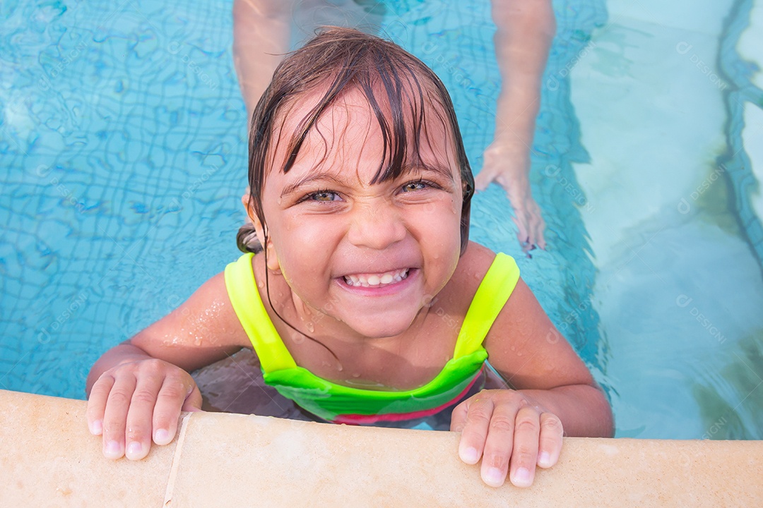 Linda menina garotinha usando roupas de banho sobre piscina curtindo verão