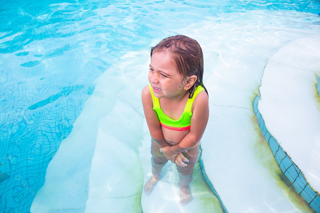 Linda menina garotinha usando roupas de banho sobre piscina curtindo verão