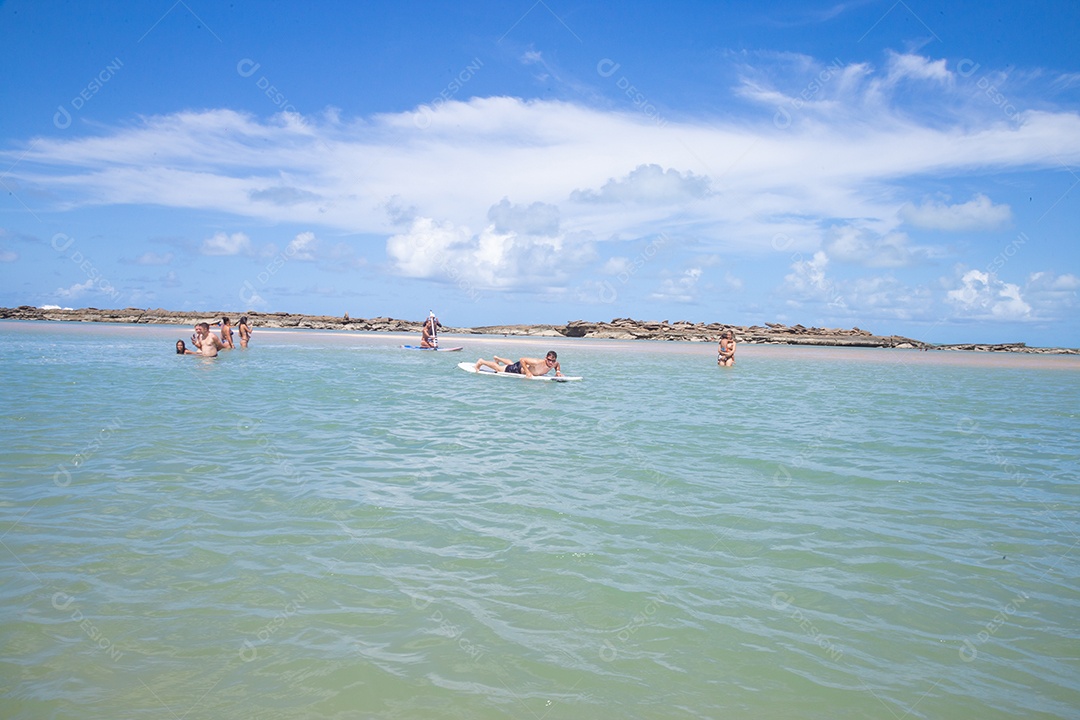 Homem jovem andando sobre prancha curtindo férias sobre uma praia